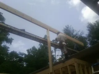 Carpenter setting a ridge beam over a new addition frame — Ice Dam Removal by Roofing Brothers in Nashville